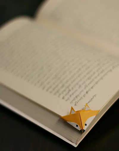 Marque-page en forme de t&ecirc;te de renard pr&eacute;sent&eacute; sur un livre ouvert